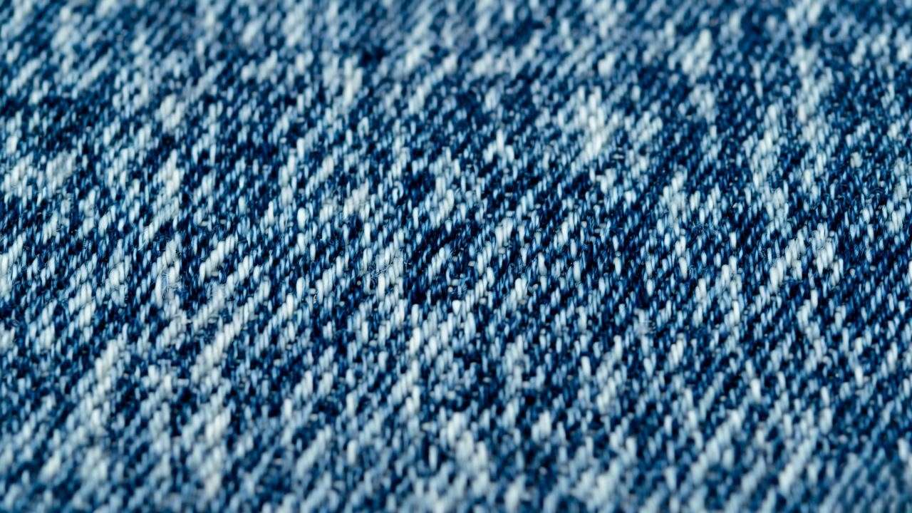 Close-up of light blue denim’s twill weave, showcasing cotton fibers for mechanical engineering applications.
