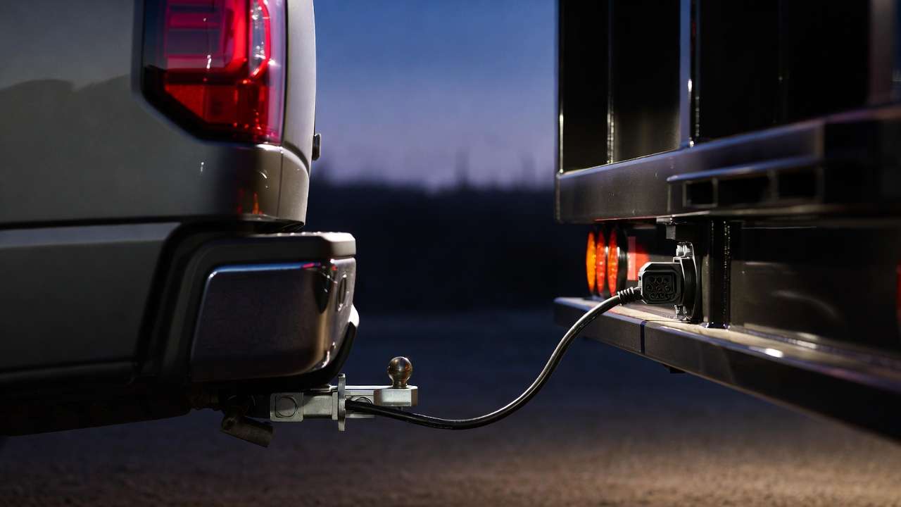 Pickup truck connected to trailer with illuminated 7-pin wiring harness demonstrating safe towing setup