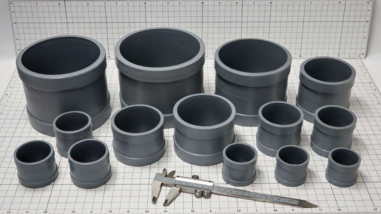 Assorted sizes of PVC pipe bushings with measurement tools for sizing guide