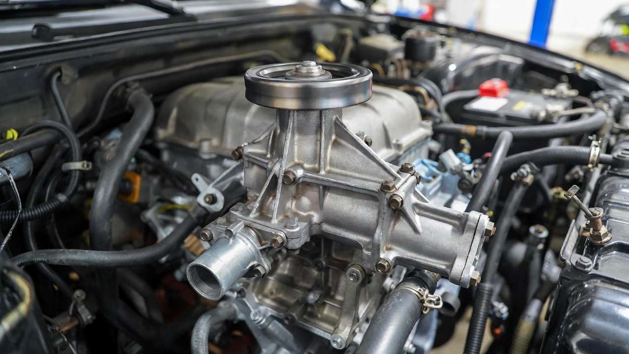 Mechanical water pump with belt drive in automotive engine cooling system.